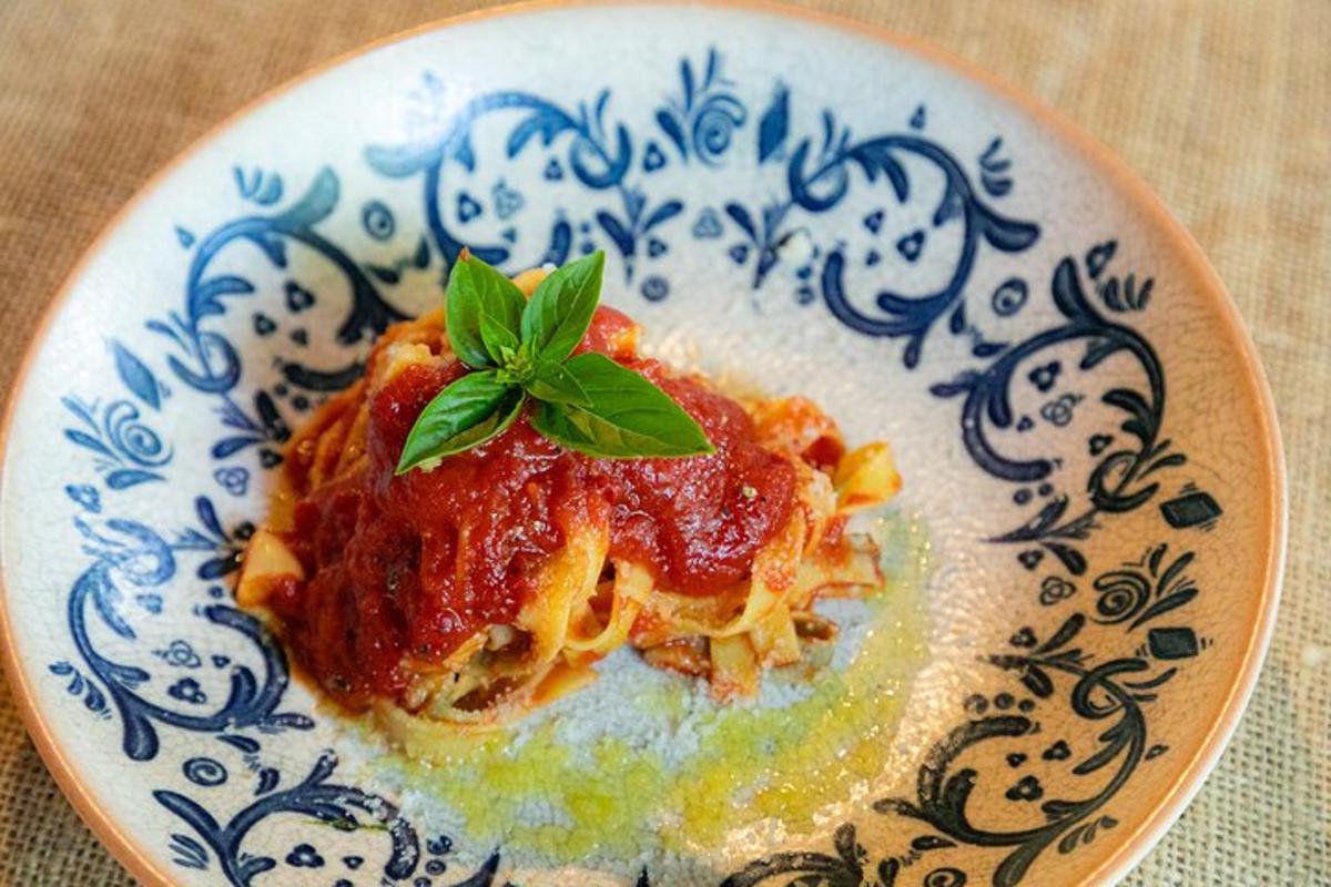 a plate of pasta with a basil leaf on it