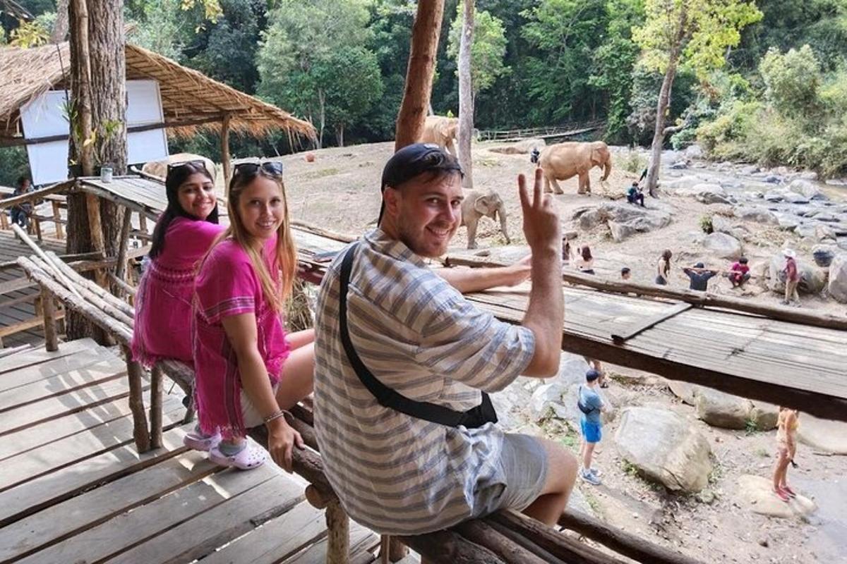 Чоловік і дві дівчинки позують для фотографії в зоопарку