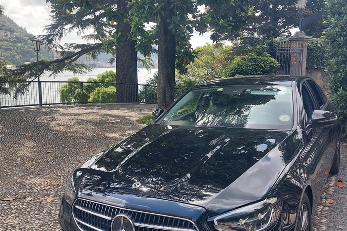 un'auto nera parcheggiata accanto a una recinzione