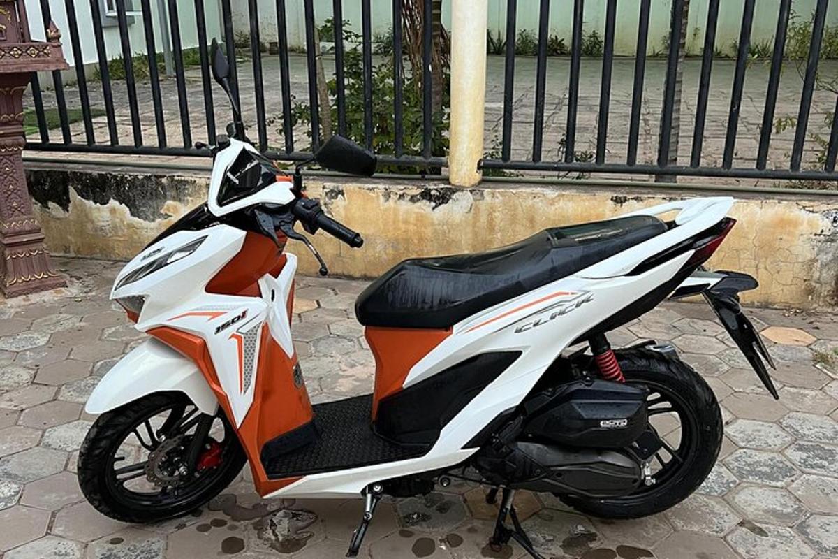 a motorcycle parked on a street next to a fence
