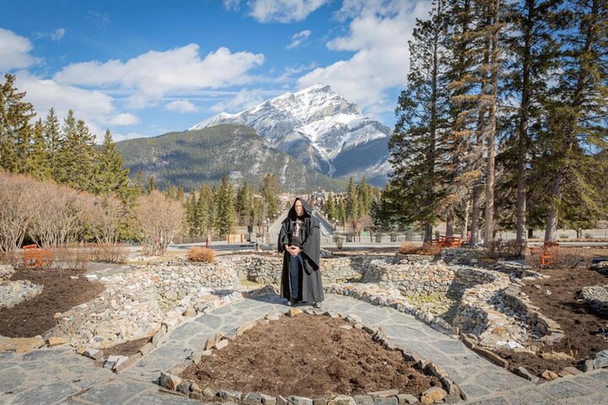 a woman standing in a garden with a mountain in the background