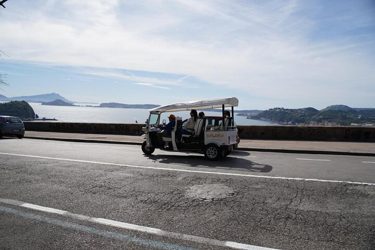 un golf cart che percorre una strada vicino all'acqua