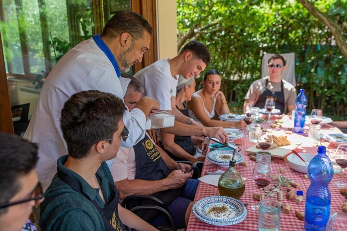 skupina lidí sedících kolem stolu a jedících