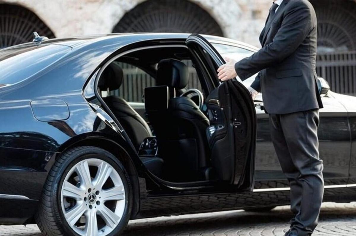 ülikonnas mees autosse istumas