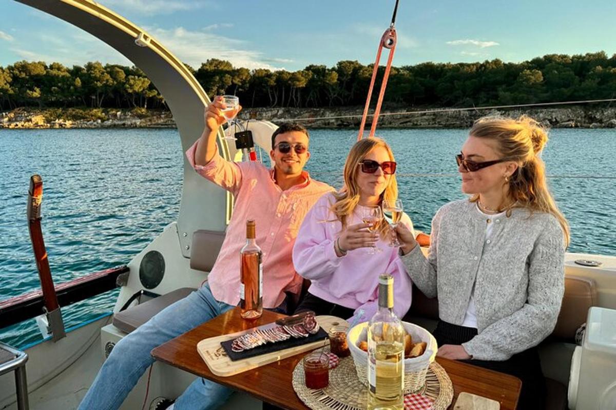 tre persone sedute su una barca con bicchieri di vino