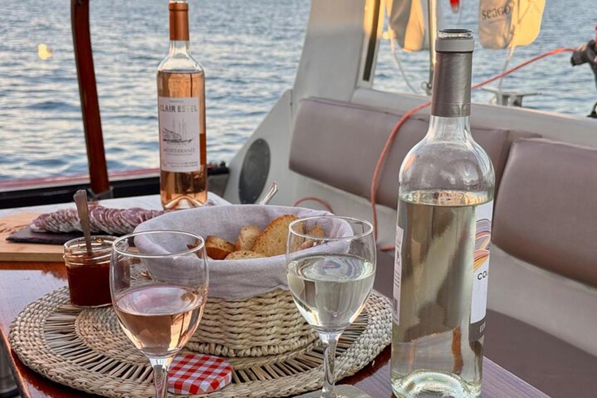 uma mesa com duas taças de vinho e uma tigela de pão