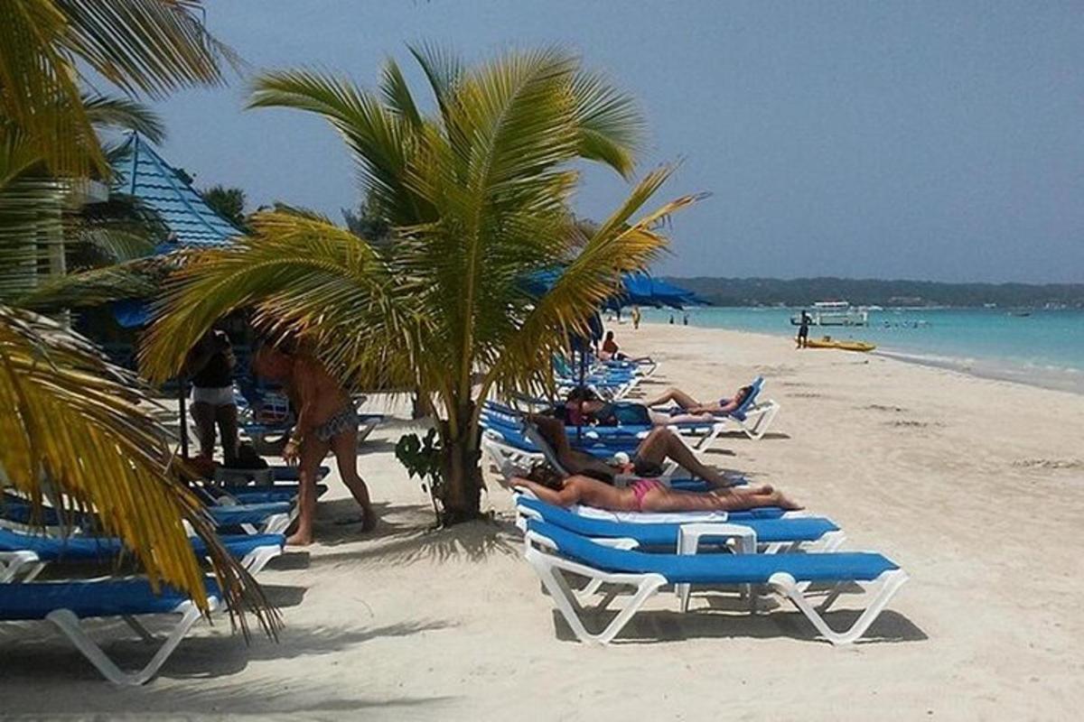 grupa ljudi leži u vrtnim stolicama na plaži