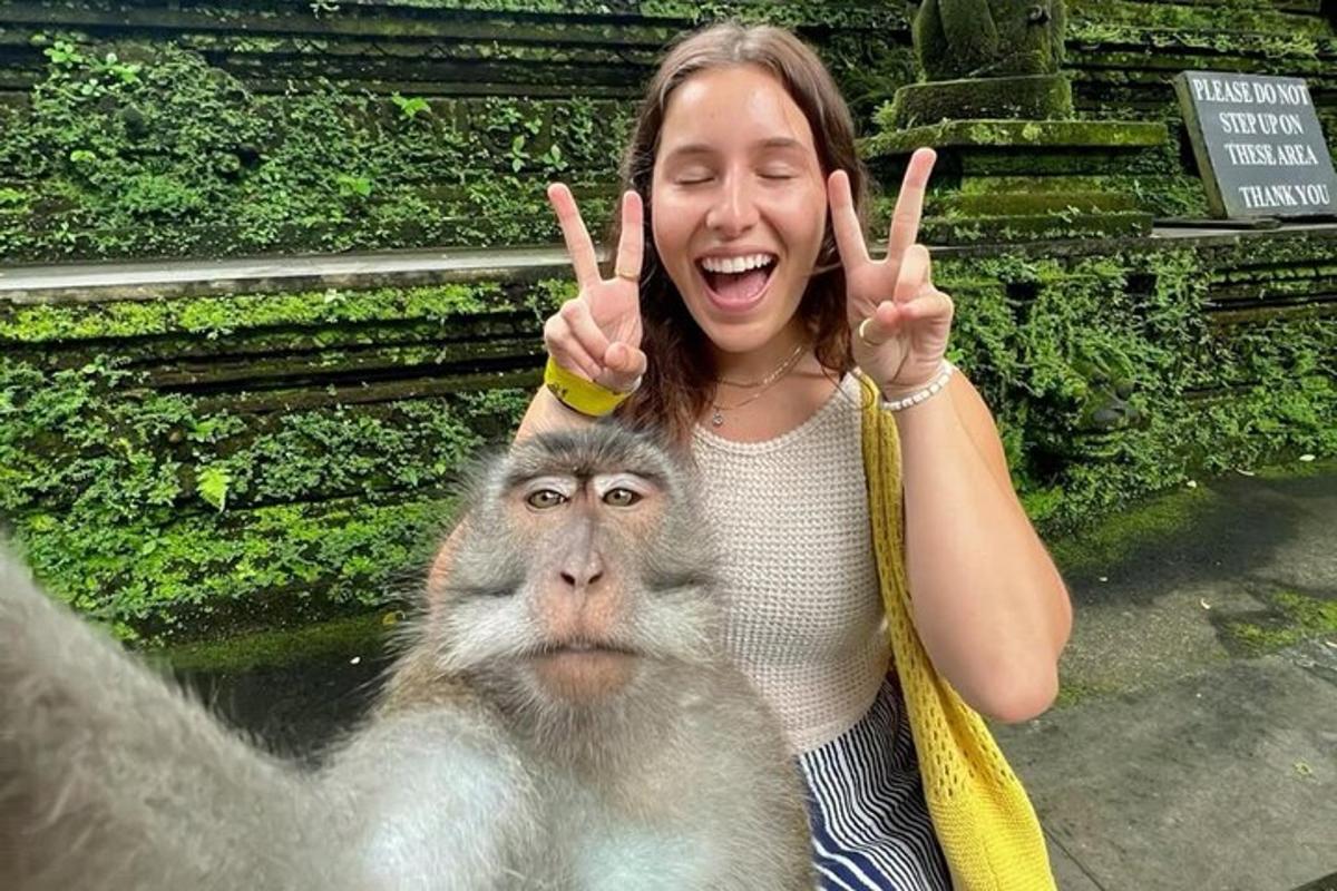een vrouw die het vredesgebaar omhoog houdt met een aap