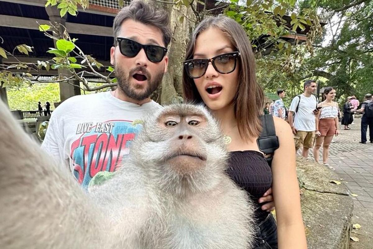 muž a žena stojící vedle opice