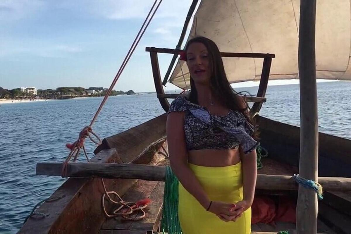 o femeie într-o rochie galbenă și neagră stând pe o barcă