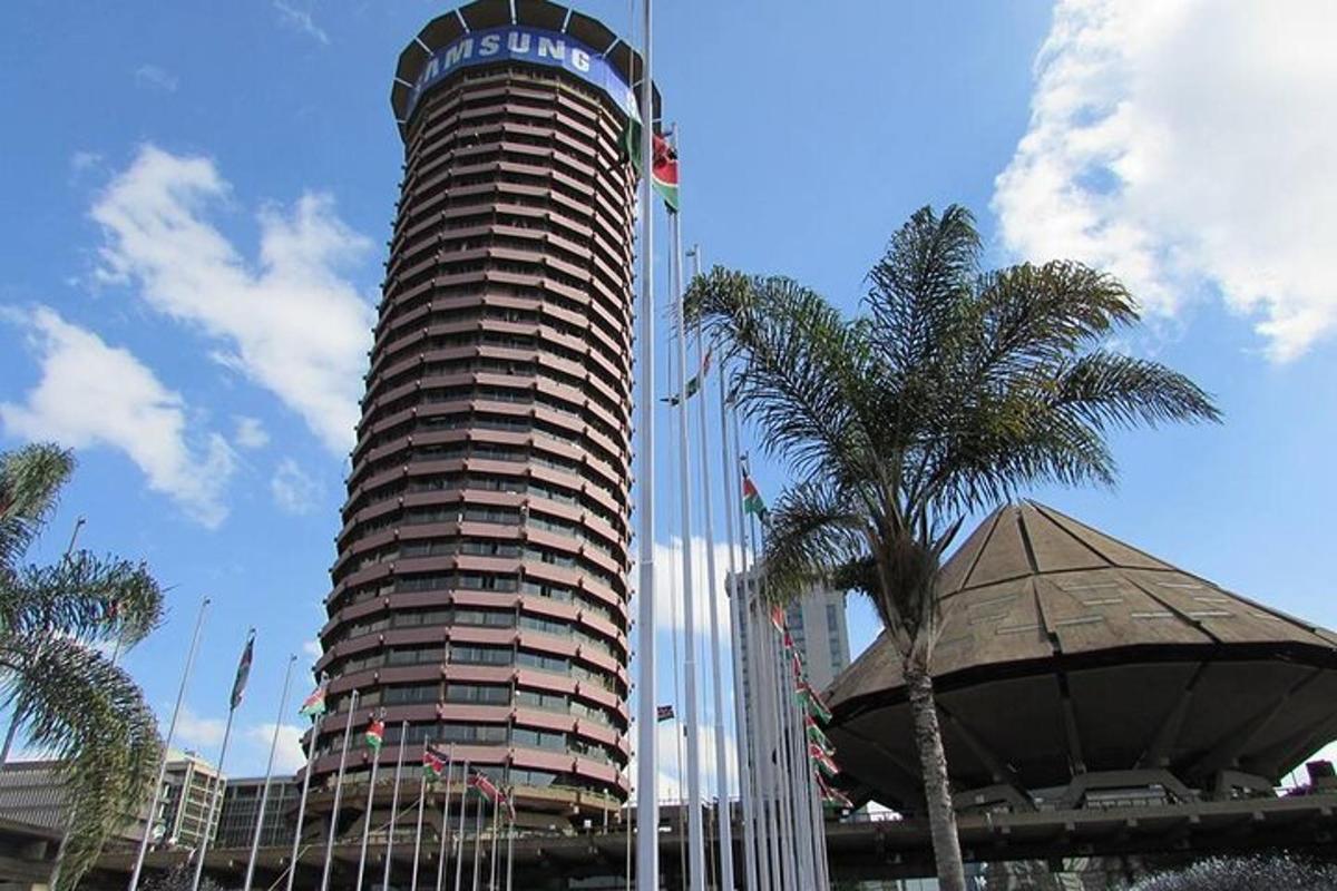 Un edificio alto con un cartel junto a palmeras.