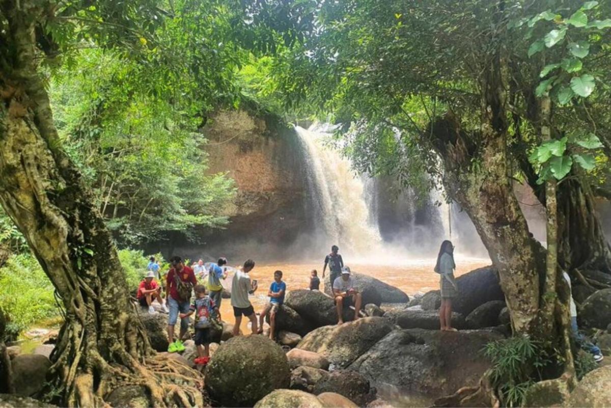 un gruppo di persone in piedi davanti a una cascata