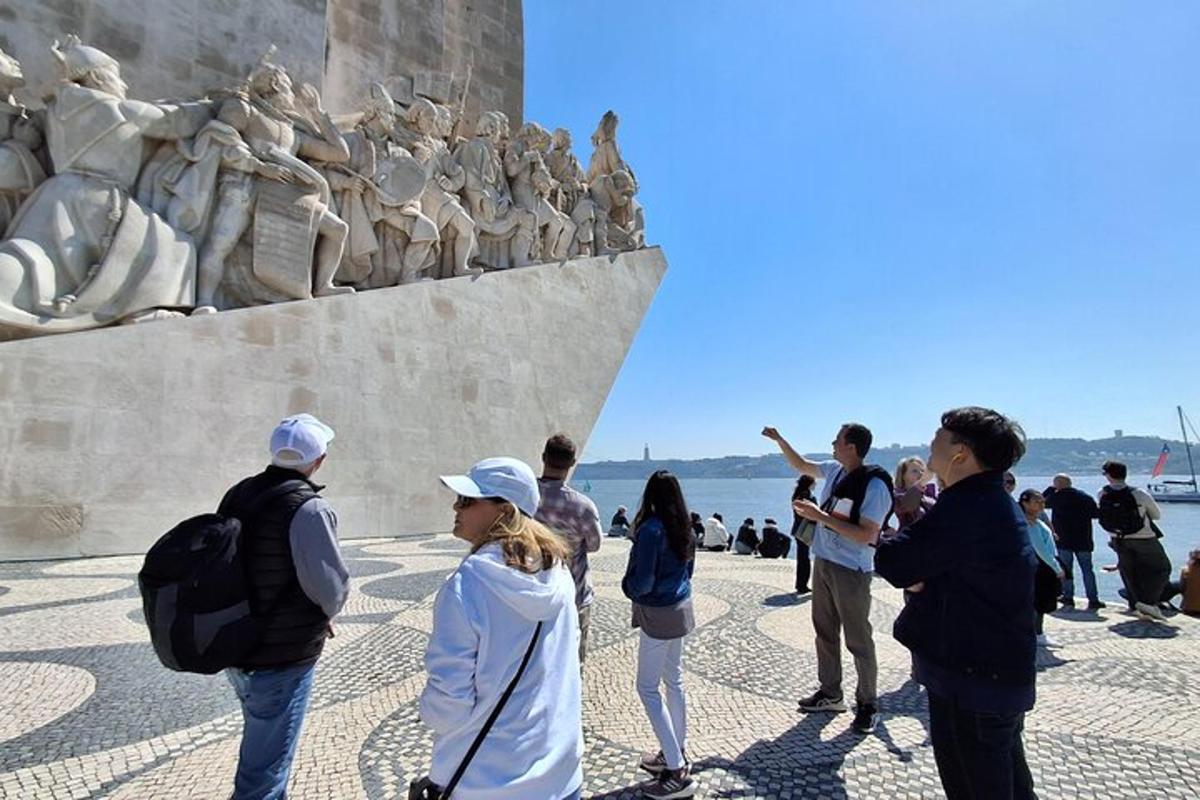 Un grupo de personas de pie frente a una estatua