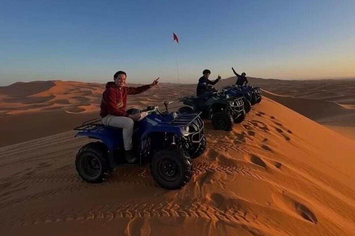 drie mensen rijden op quads in de woestijn
