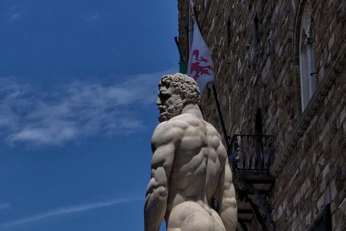 una statua di un uomo in piedi accanto a un edificio