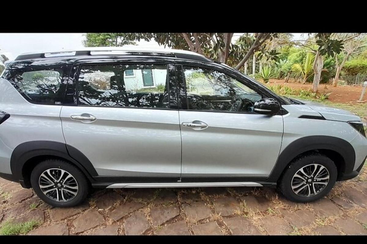 um carro prateado estacionado em uma estrada de terra