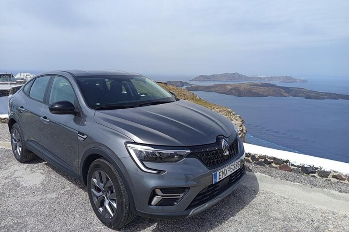 a silver car parked on a road near the ocean