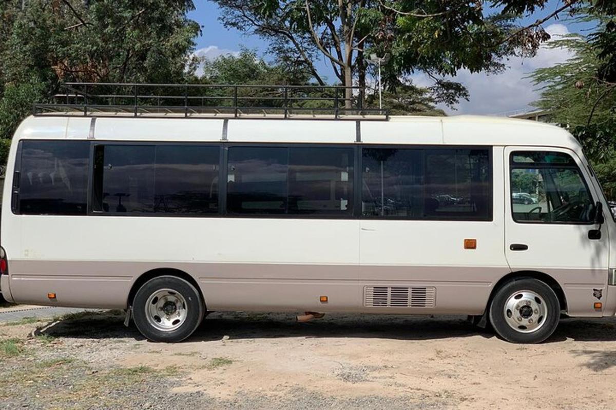 sebuah van putih terparkir di tanah lapang