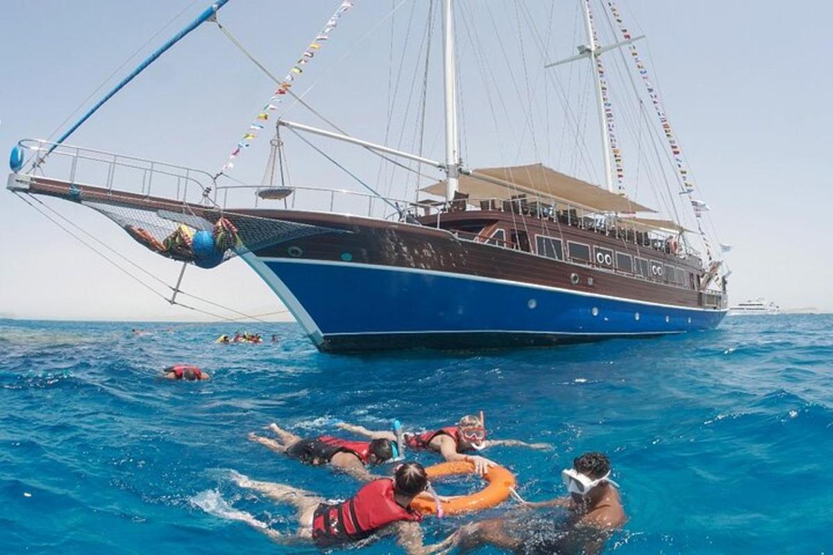 um grupo de pessoas nadando no oceano ao lado de um barco