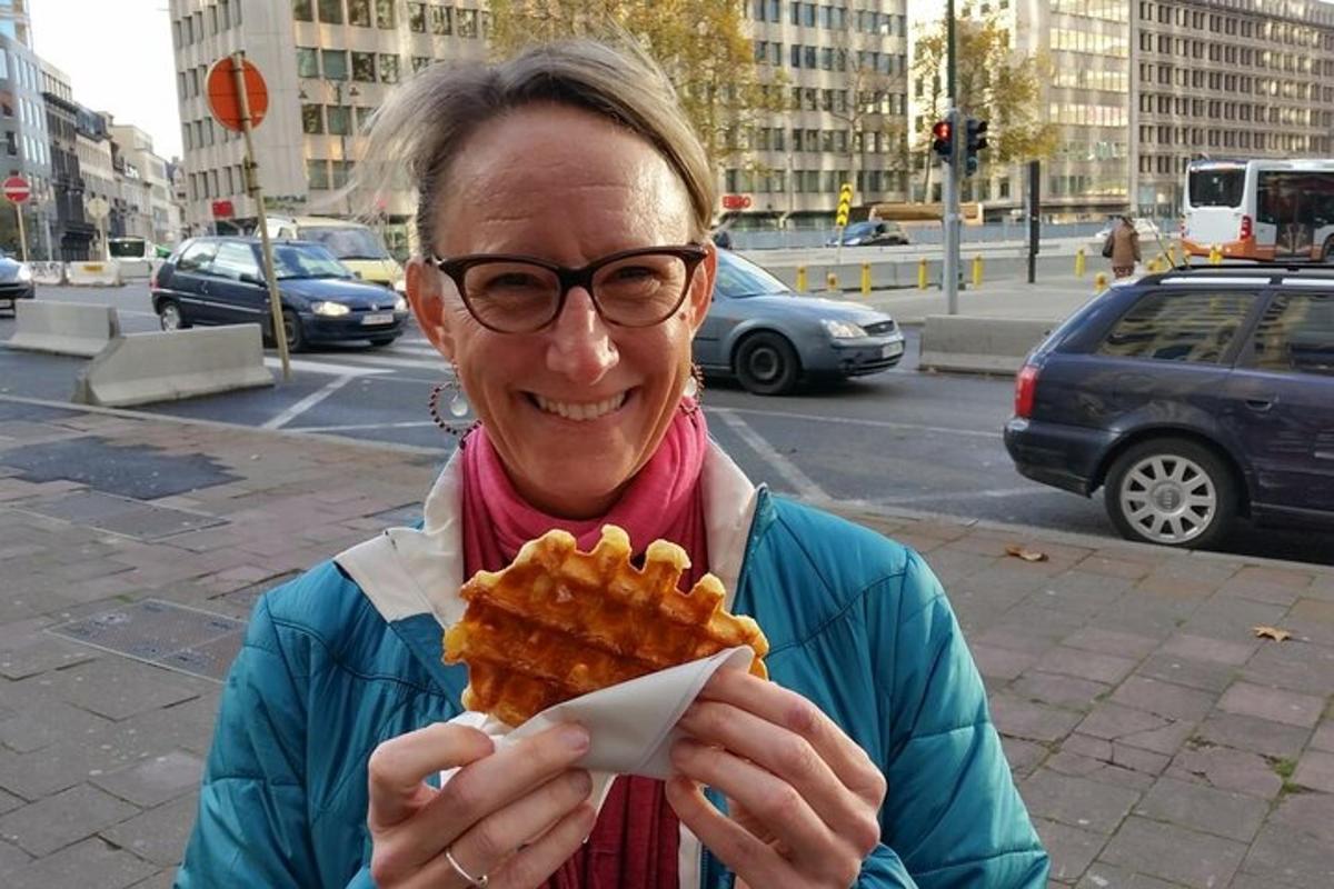 Kona brosir og heldur á diski af vöfflum