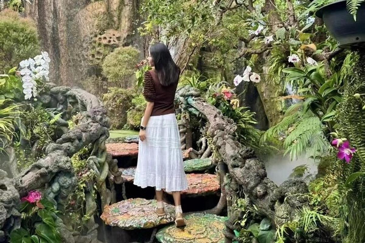 una donna in piedi su una panchina in un giardino