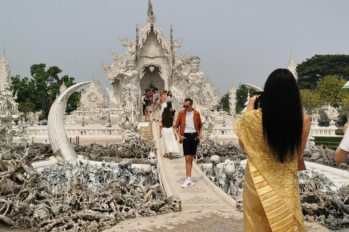 o femeie care fotografiază un bărbat care merge printr-un templu