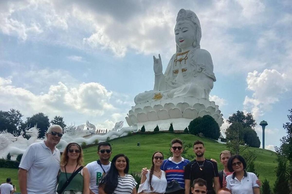 un grup de oameni care stau în fața unei statui mari