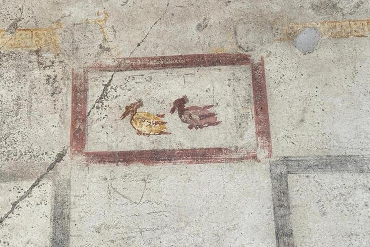uma pintura de dois pássaros em um chão de pedra