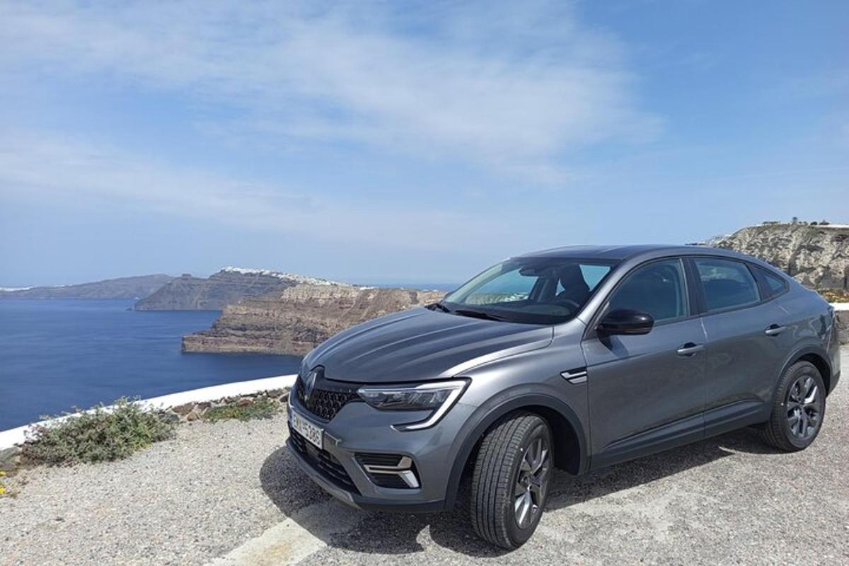 un'auto argentata parcheggiata su una strada vicino all'oceano