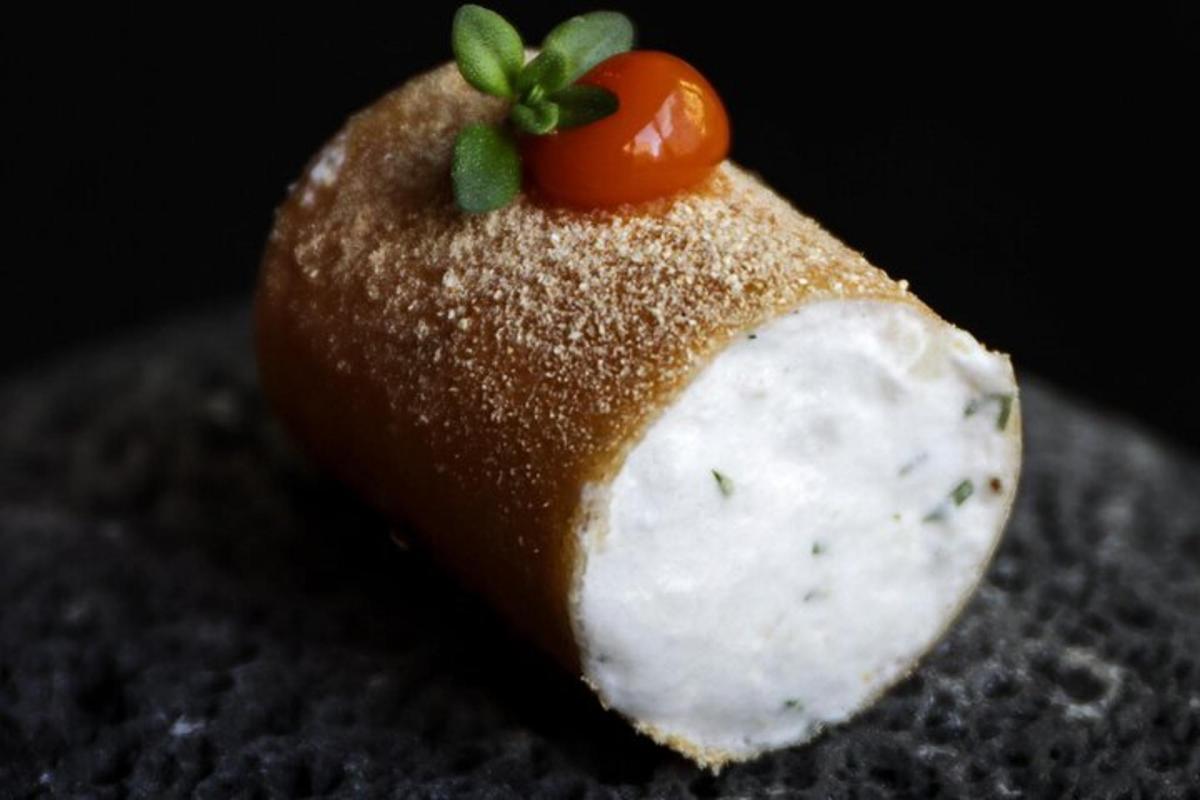 ein Stück Essen mit einer Tomate darauf