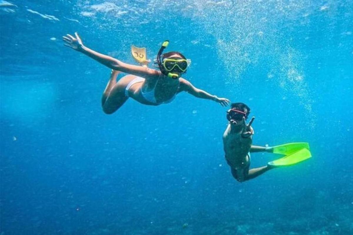 two people are swimming in the blue water
