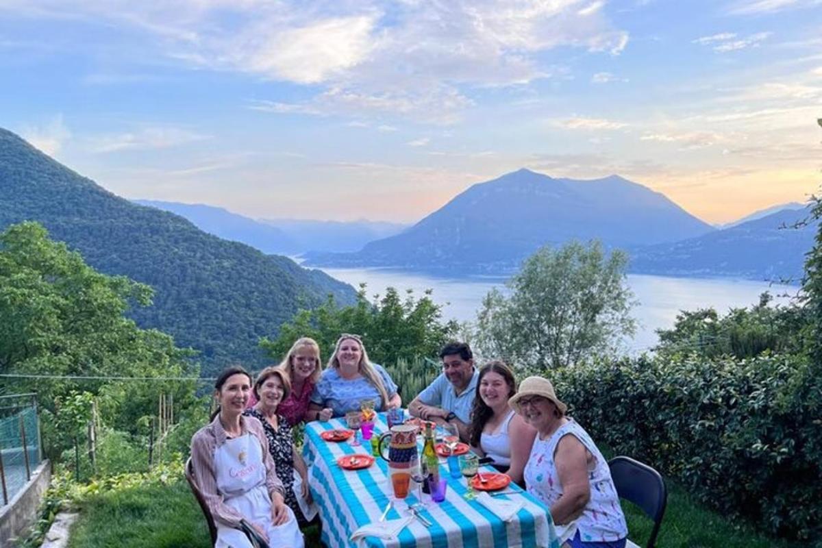 un gruppo di persone sedute a un tavolo con le montagne sullo sfondo
