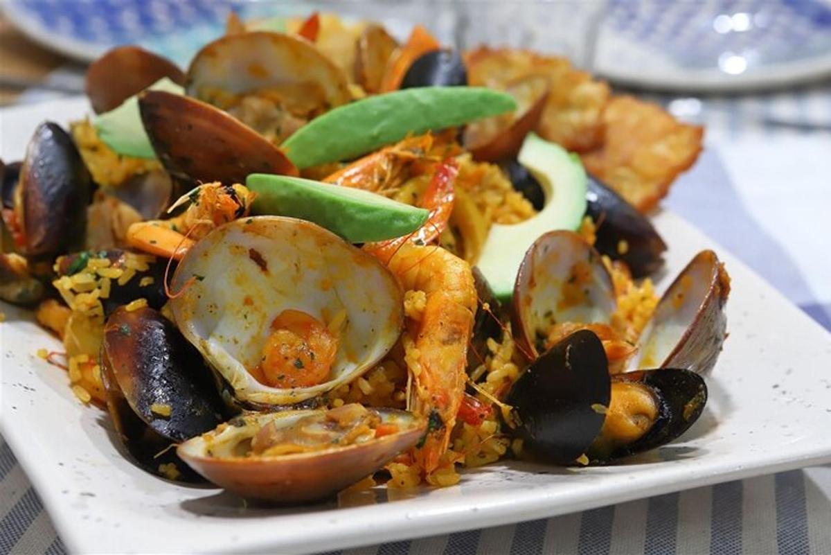 talíř jídla s mořskými plody a rýží na stole