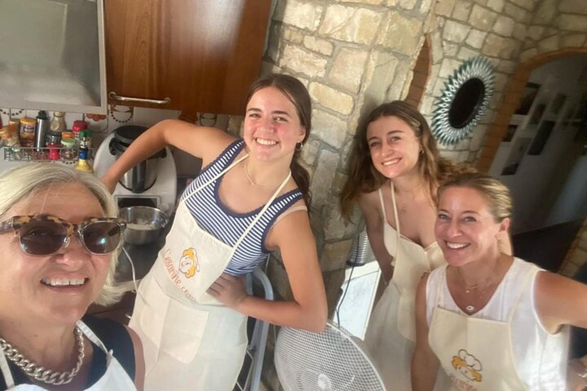 Eine Gruppe von Frauen steht in einer Küche und hält Tennisschläger
