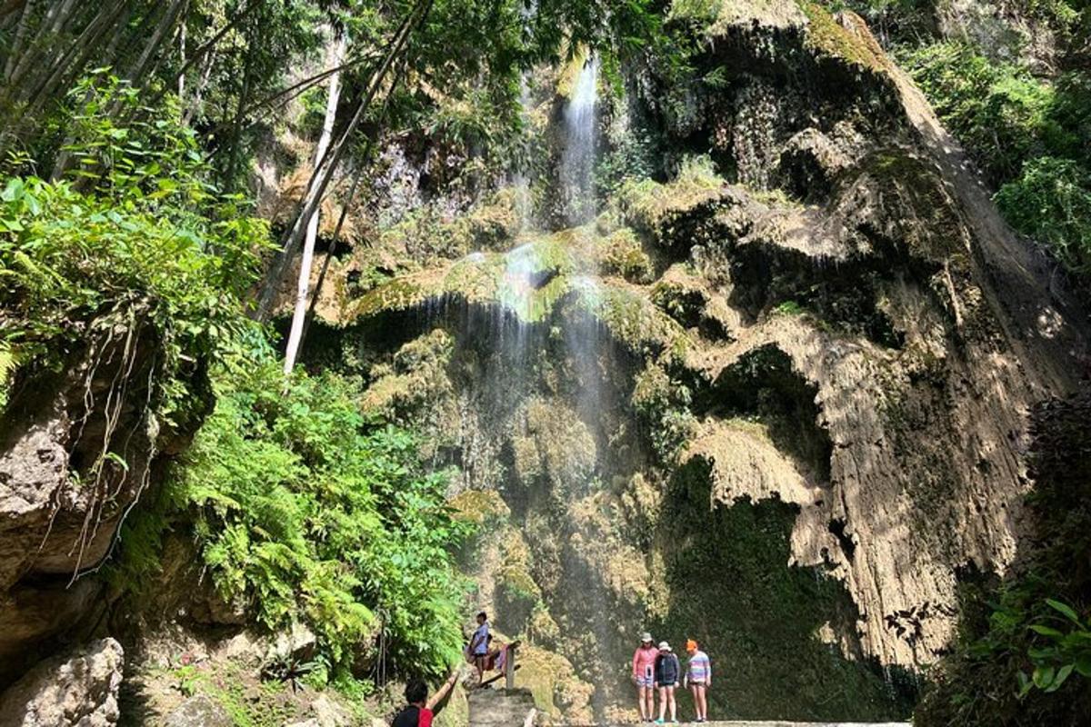 eine Gruppe von Menschen steht vor einem Wasserfall