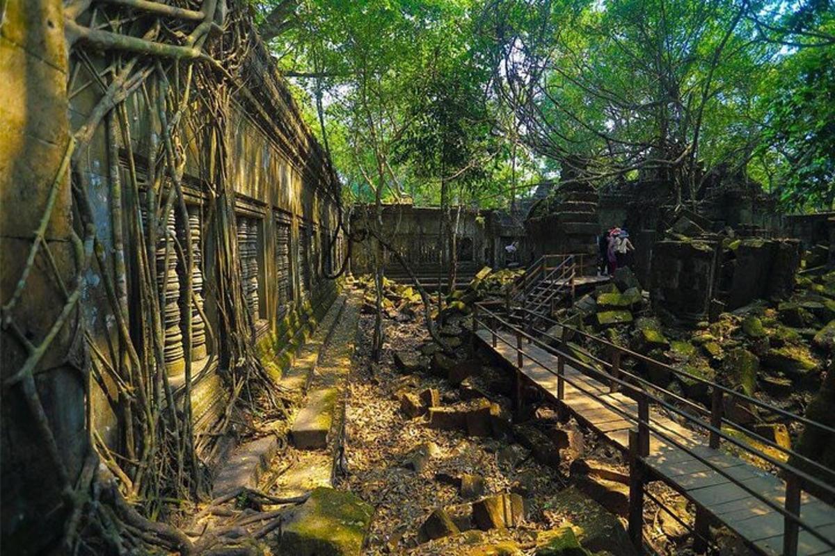 một sân ga xe lửa cũ với cây cối và một tòa nhà