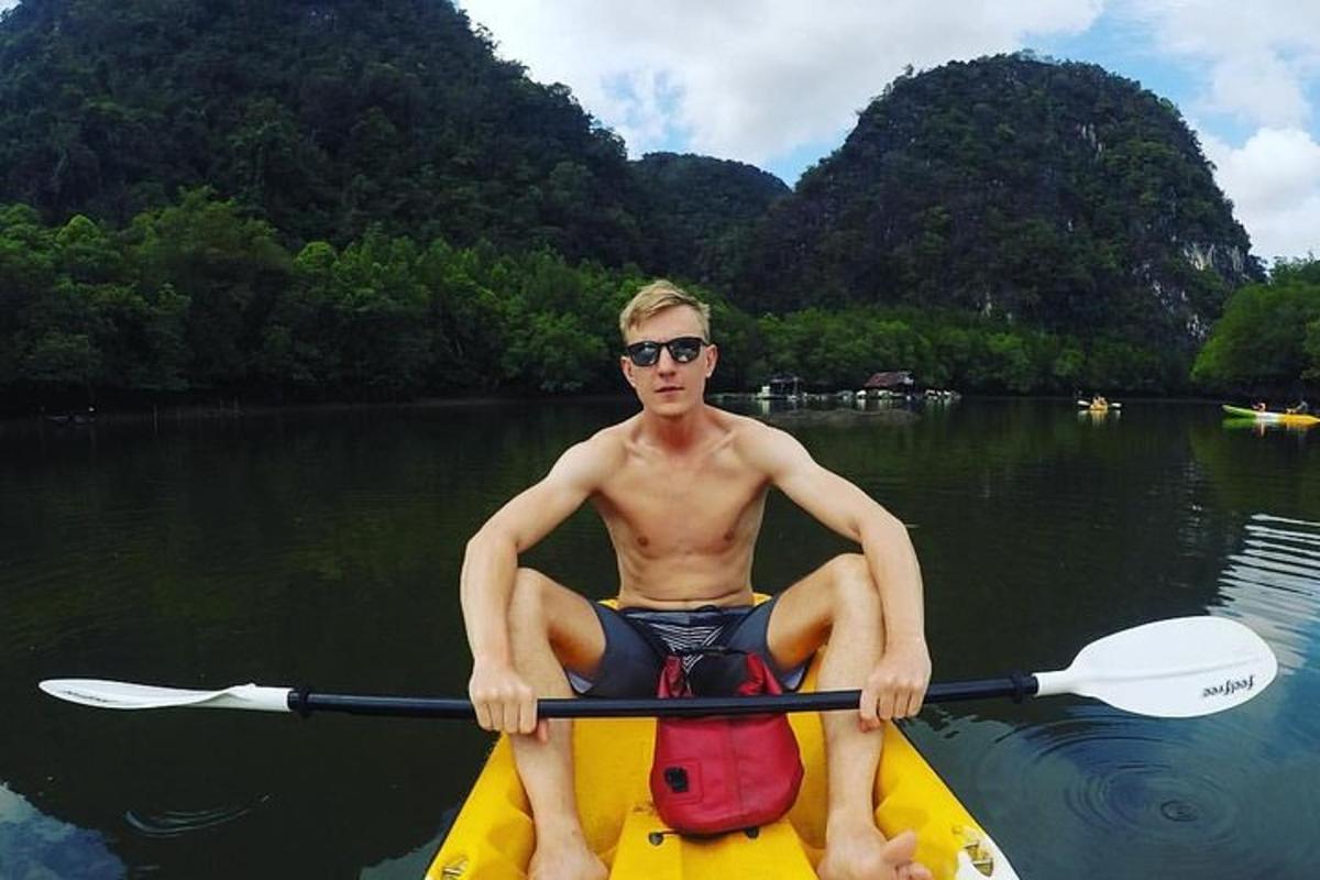 một người đàn ông đang ngồi trên thuyền kayak dưới nước