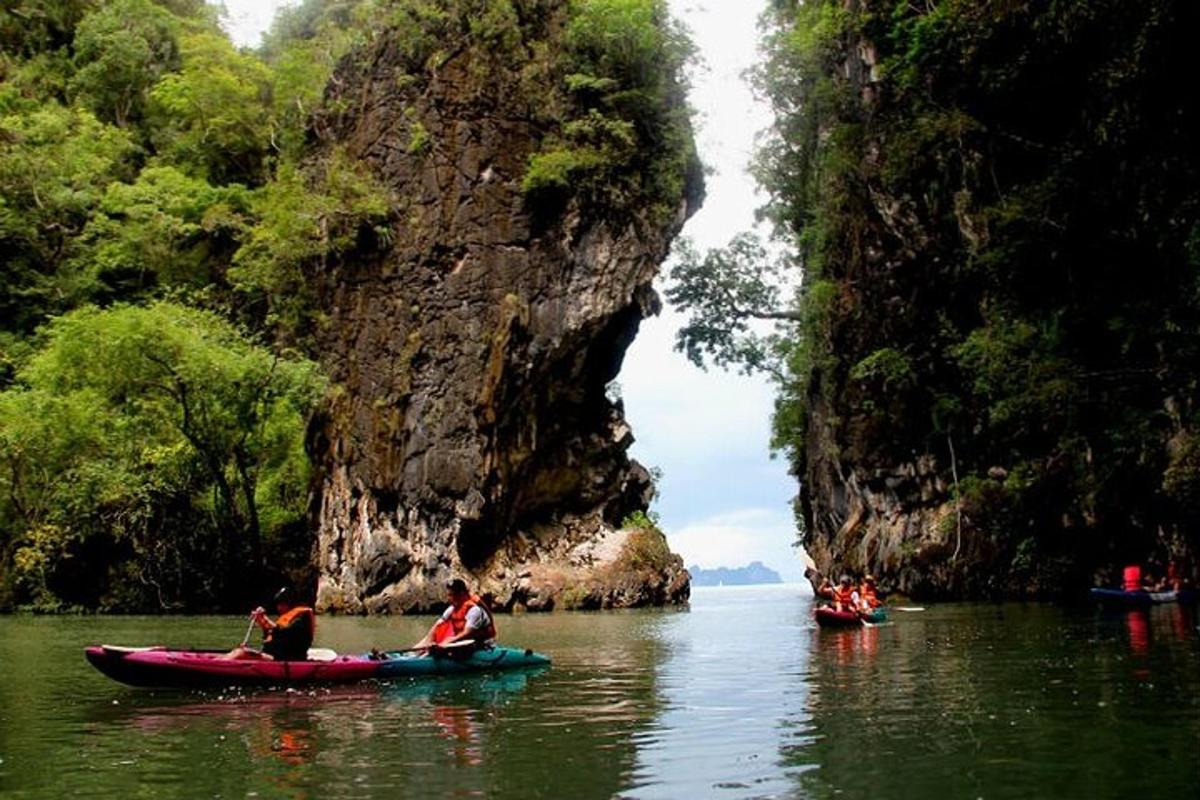 sekumpulan orang berkayak di dalam air berhampiran tebing