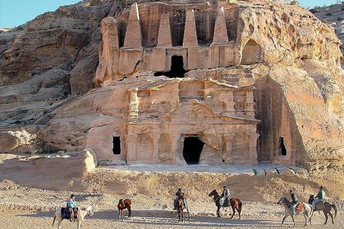 un gruppo di persone a cavallo davanti a un antico edificio