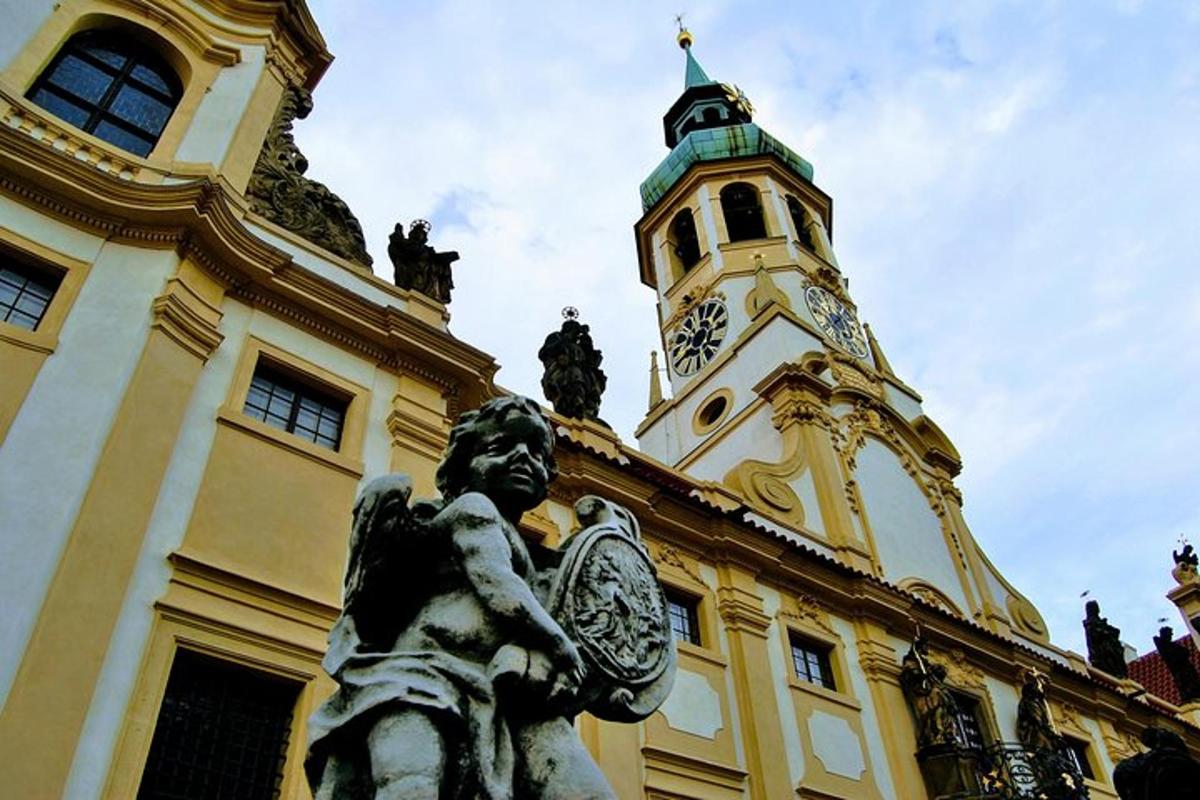 statua przed budynkiem z wieżą zegarową