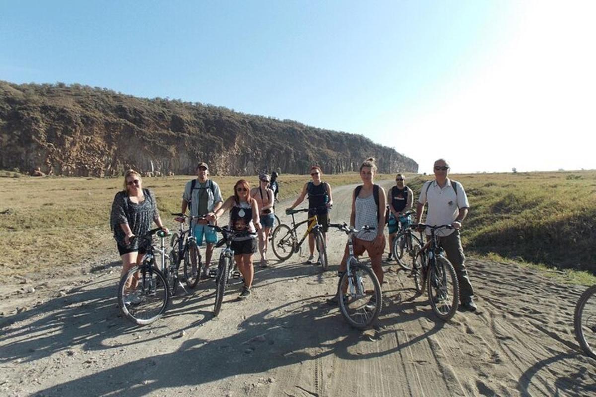 un grup de oameni care merg cu bicicleta pe un drum de pământ