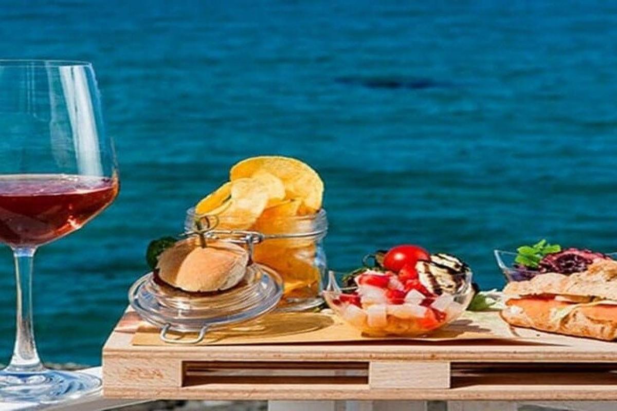 un tavolo con un bicchiere di vino e del cibo