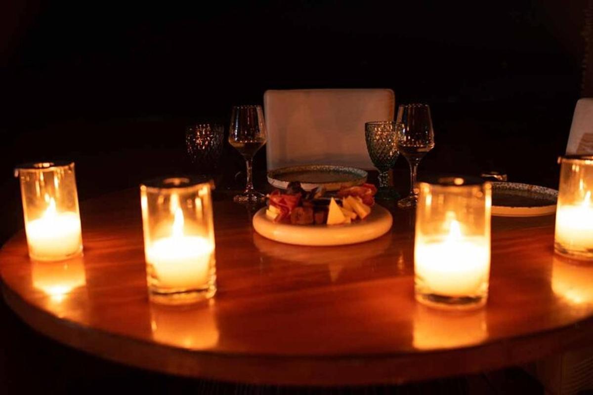 miza s svečami in krožnikom hrane ter kozarci za vino