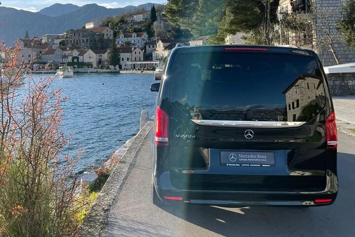 un furgone verde parcheggiato accanto a uno specchio d'acqua