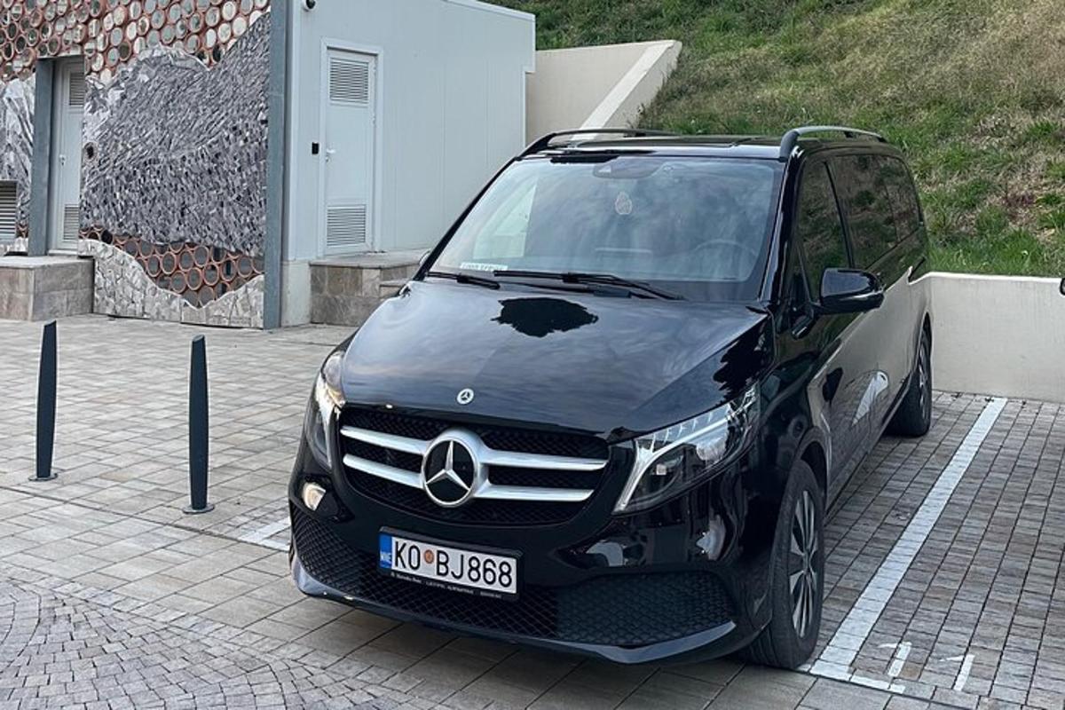 en svart bil parkert på en parkeringsplass