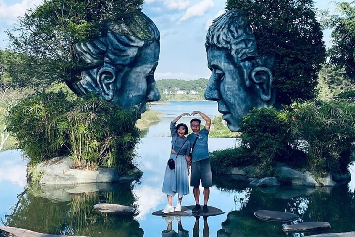 two people standing in front of a statue in the water