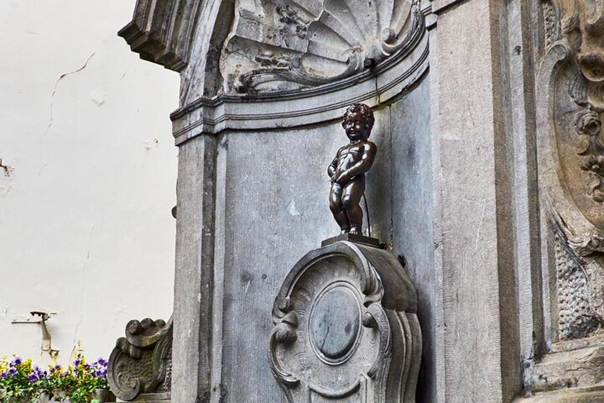 uma estátua de uma menina na lateral de um prédio