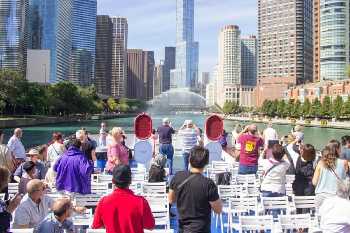 a group of people sitting on white chairs in front of a city