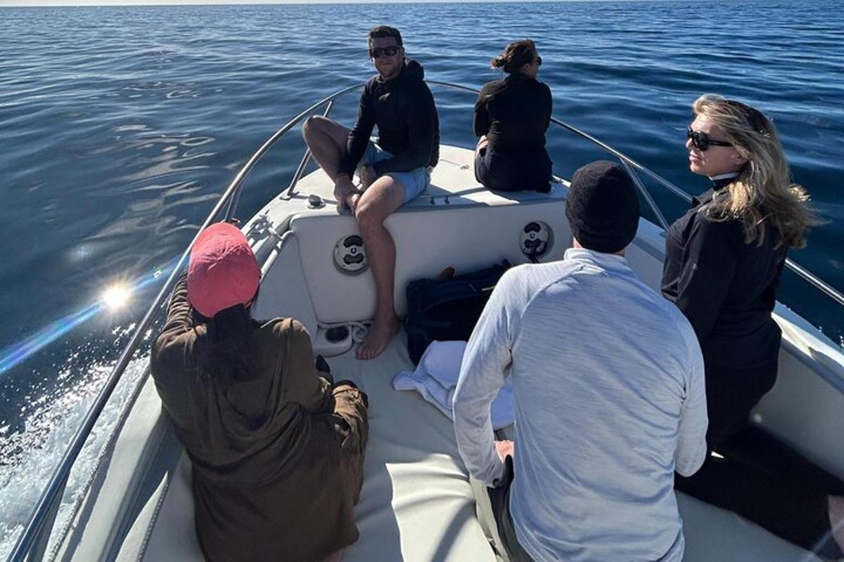 un gruppo di persone sedute su una barca in acqua