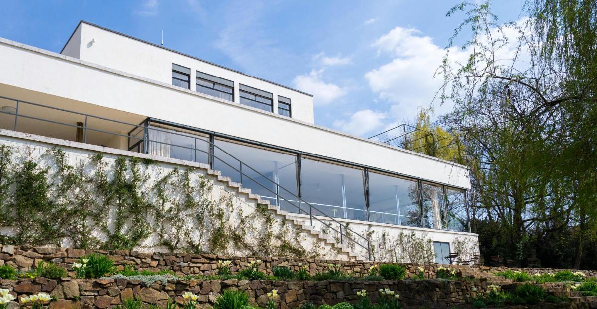 uma casa branca com um muro de pedra